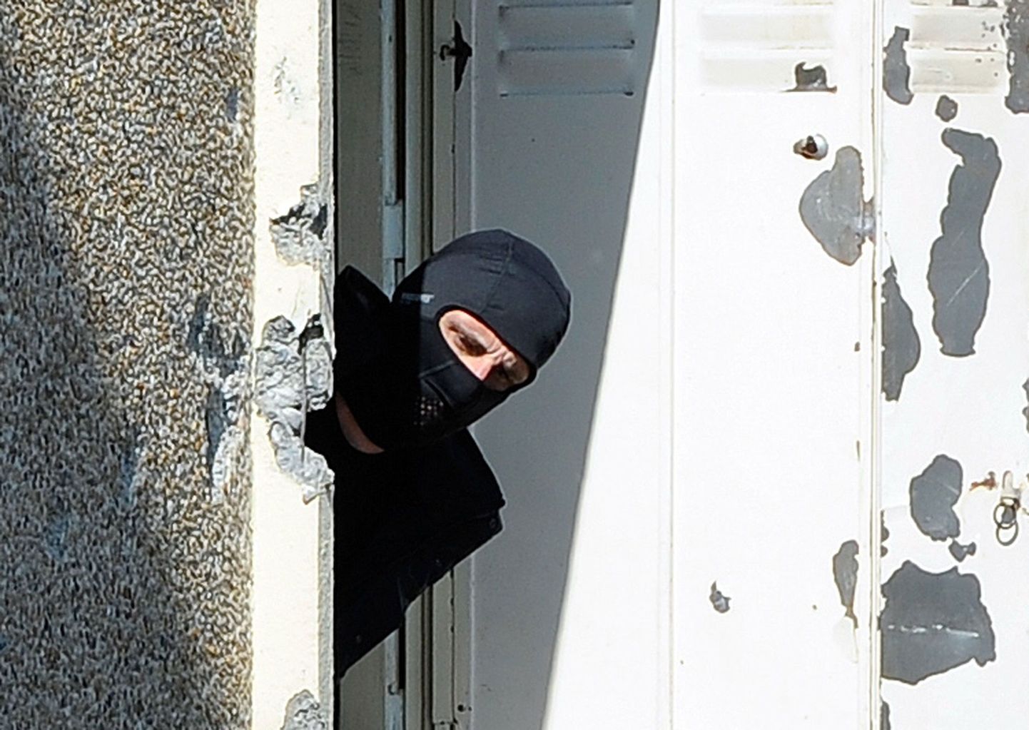 Maskiga politseinik kiikamas välja korterist, kus elas Mohammed Merah.