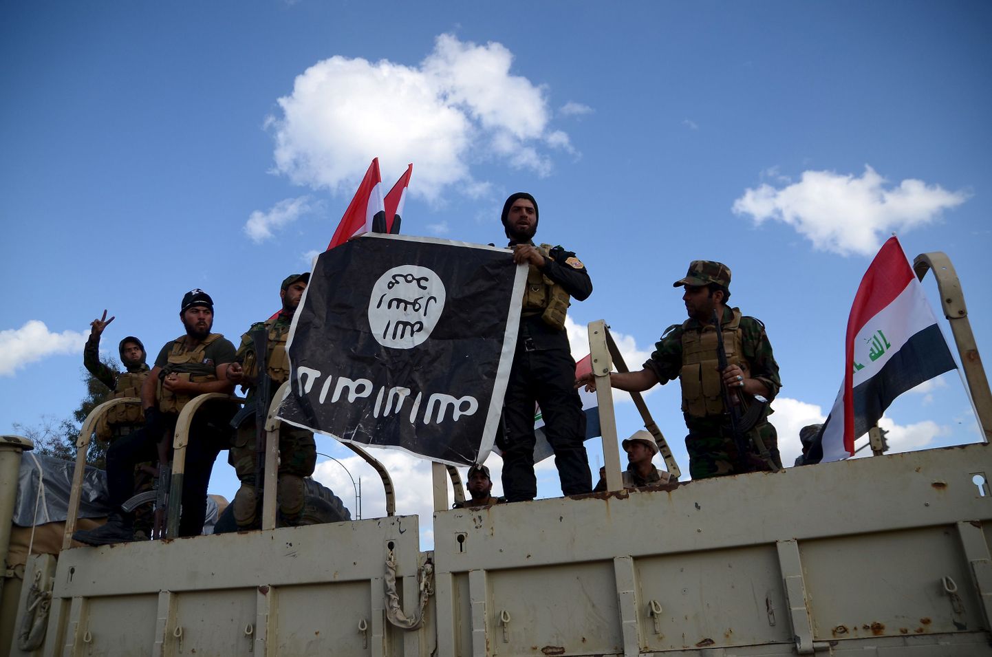 Šiitidest võitlejad lehvitavad Islamiriigi lippu, mille nad rebisid alla Tikritis.