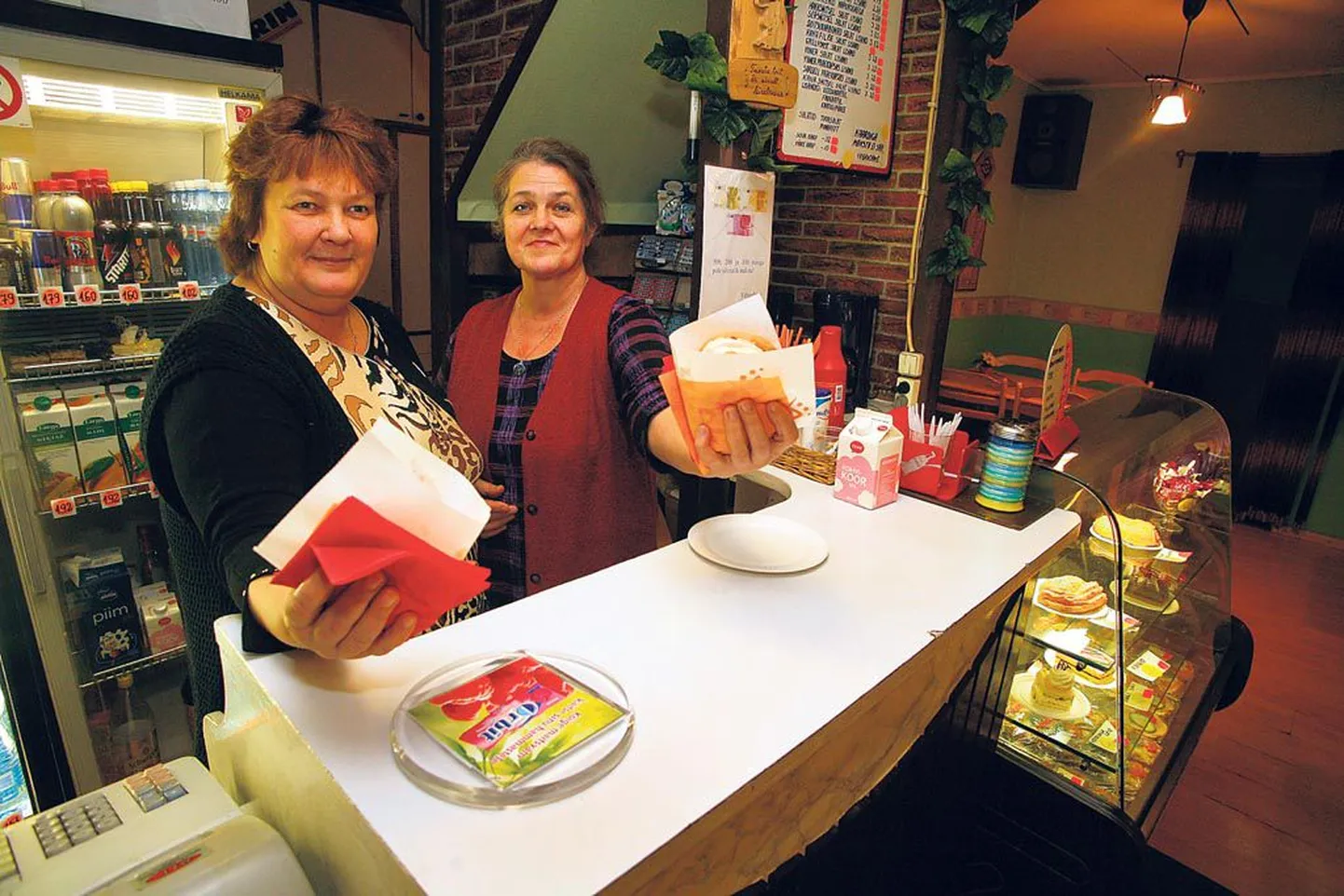 Piiri kohviku müüjanna Marge Prikmann (esiplaanil) ja kohviku omanik Anne Talv eksponeerivad uhkelt kohviku kauaaegseid menukeid – eestipäraseid burgereid. Neid tullakse ostma nii maalt kui linnast.