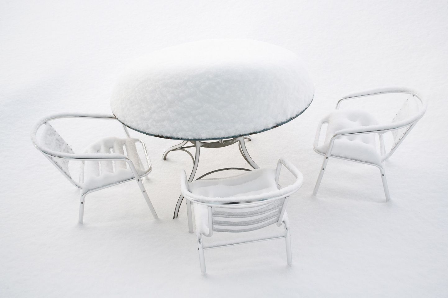 Üle talve õues seisnud aiamööblile saab koduste vahenditega anda uue välimuse. Pildil lumega kaetud aiatoolid ja -laud.