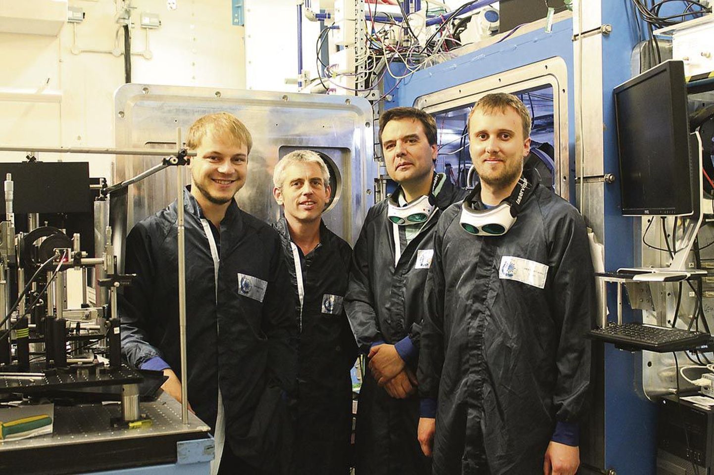 Kristjan Põdra (vasakul) kõrval seisavad tema kolleegid Dan Symes, Nelson Lopes-Carreira ja Jon Wood kohas, kus teadust tehakse ehk Central Laser Facility labori laseriruumis.