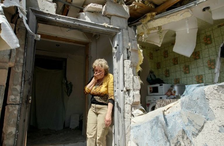 Женщина на развалинах своего дома в районе АТО неподалеку от Донецка, май 2016 
