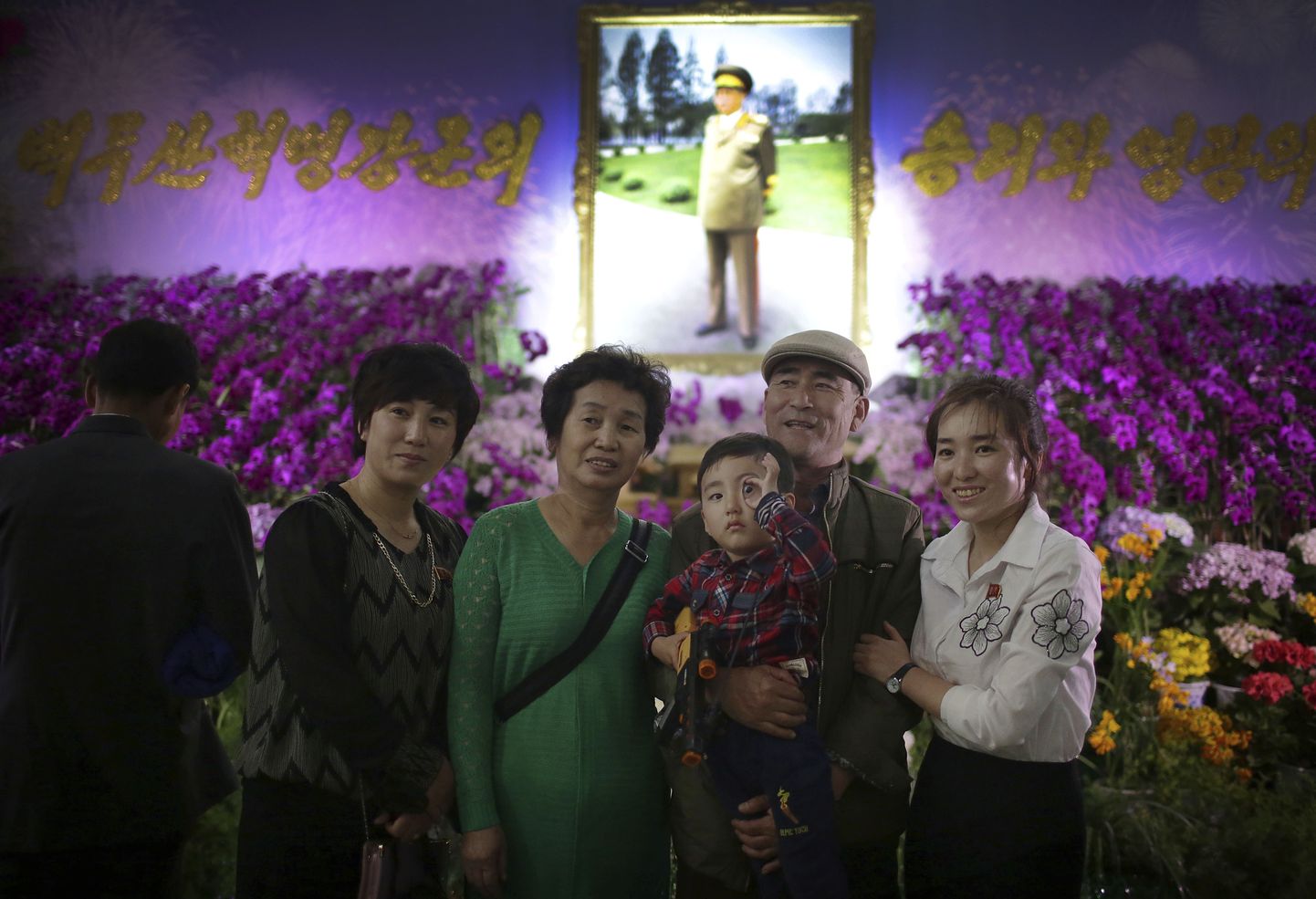 Северокорейская семья позирует на фестивале цветов.