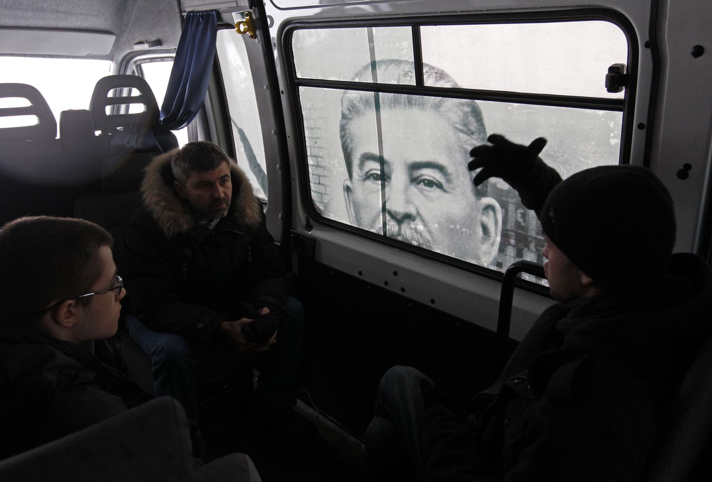 Reisijad  jutlevad Stalini plakatiga kaunistatud bussis.