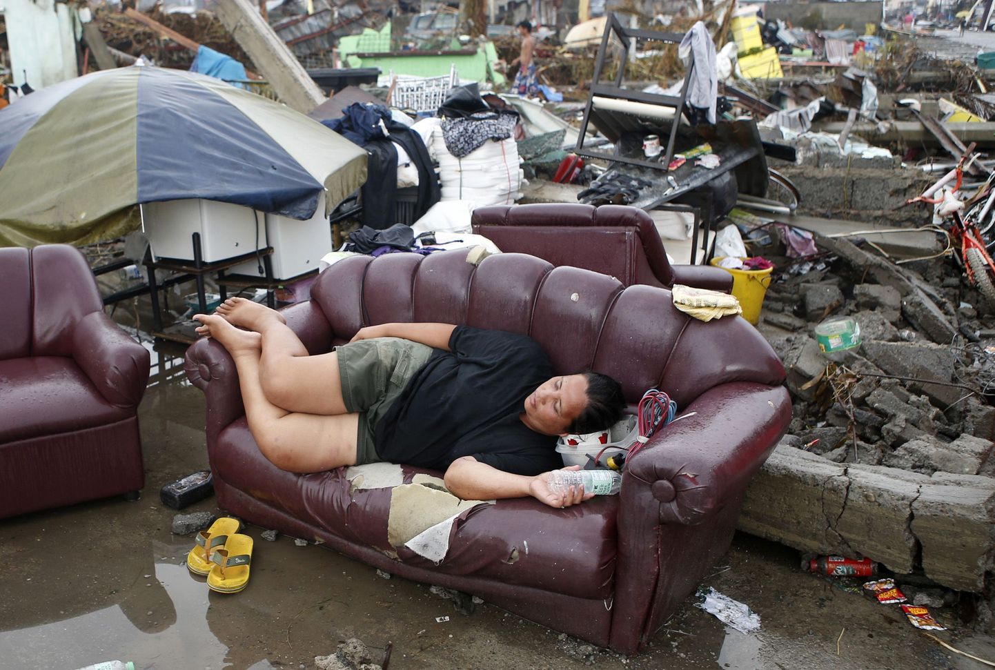 Taifuuni tõttu kodu kaotanud filipiinlane täna Palo oma maja rusude juures diivanil puhkamas.
