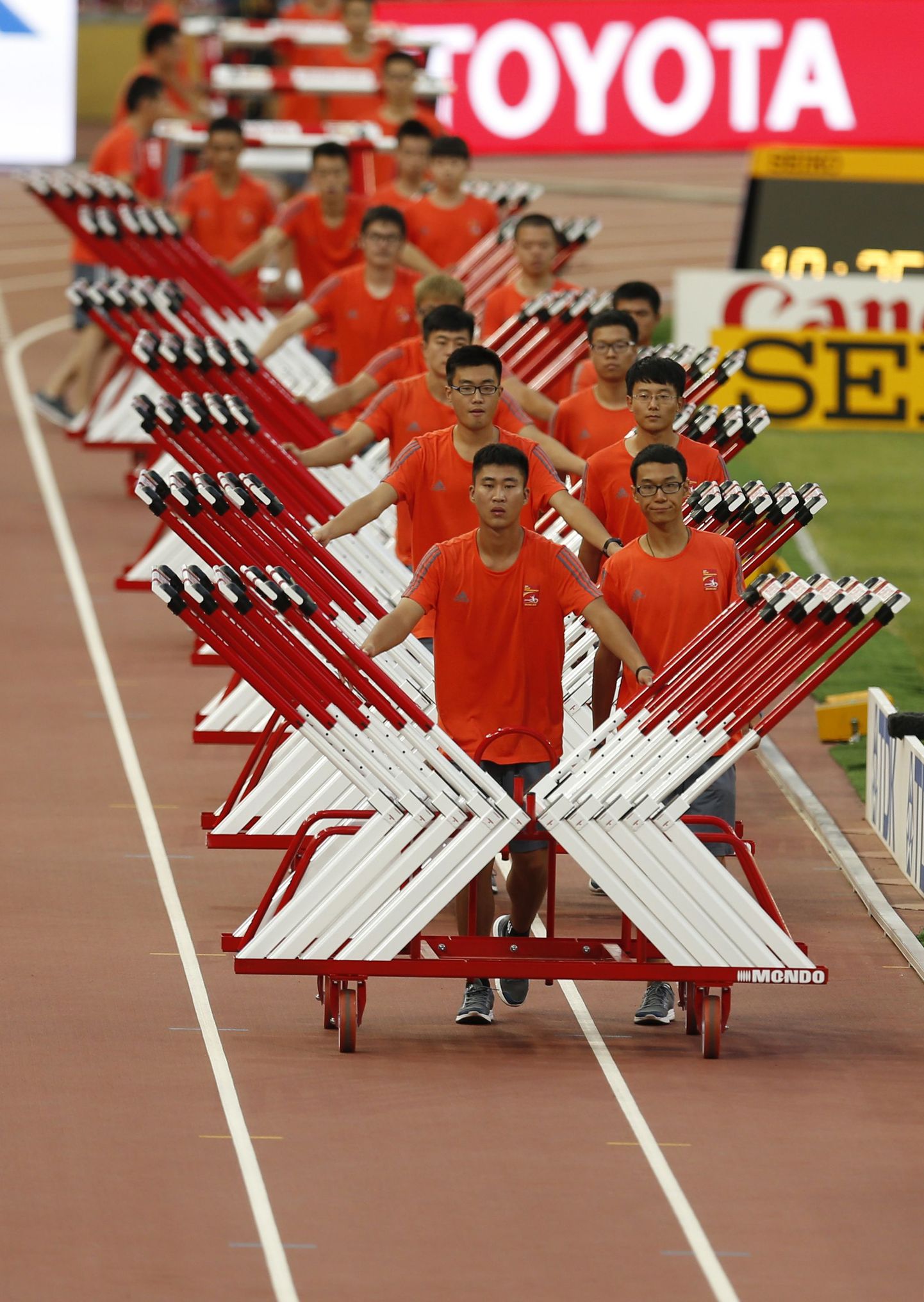 Vabatahtlikud Pekingi MMil tõkkejooksu tarbeks tõkkeid laiali vedamas.