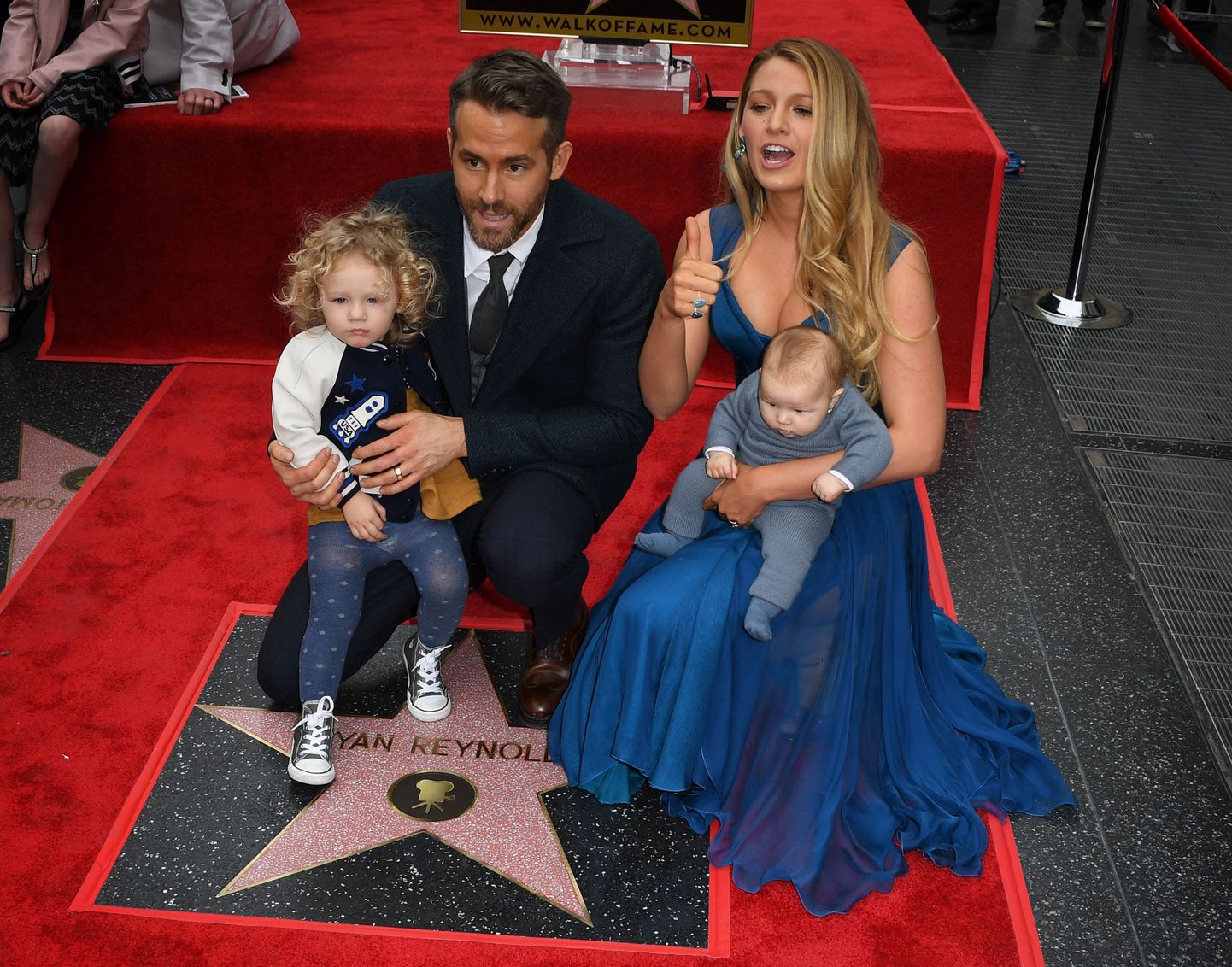 Actor Ryan Reynolds (2L) holds his daughter James as his wife Blake Lively holds their unnamed new baby during the Deadpool actor