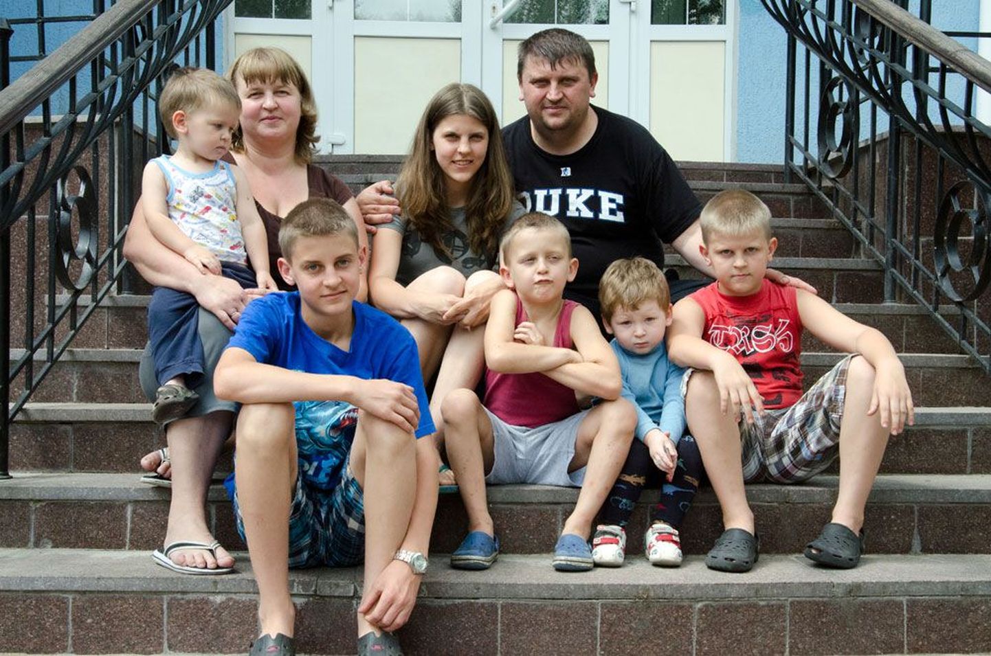 Петр с супругой и пятью детьми позирует на лестнице перед санаторием. С ними – один из друзей детей.