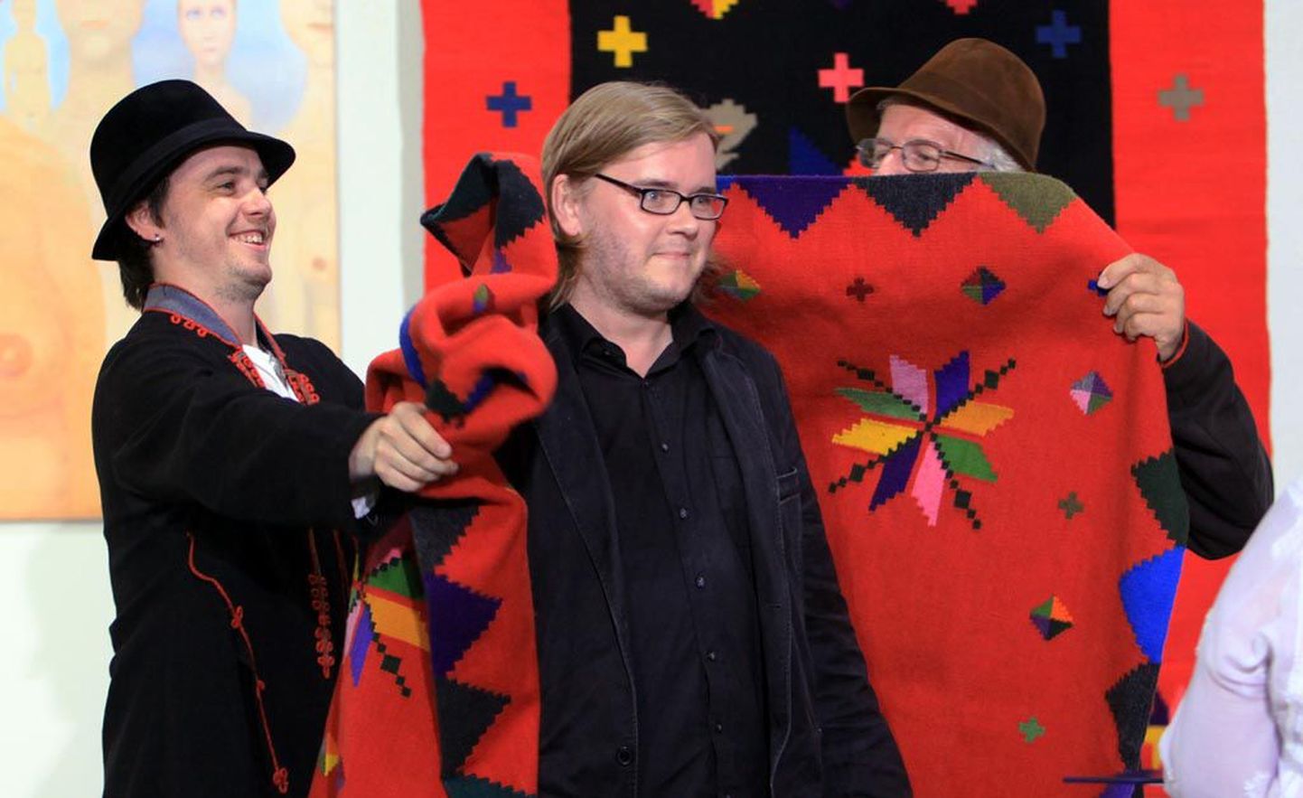Filmifestivali korraldajad Vaiko Edur (vasakul) ja Mark Soosaar panevad Mika Hotakainenile ümber festivali suure auhinna, Lääne-Eesti pulmavaiba.