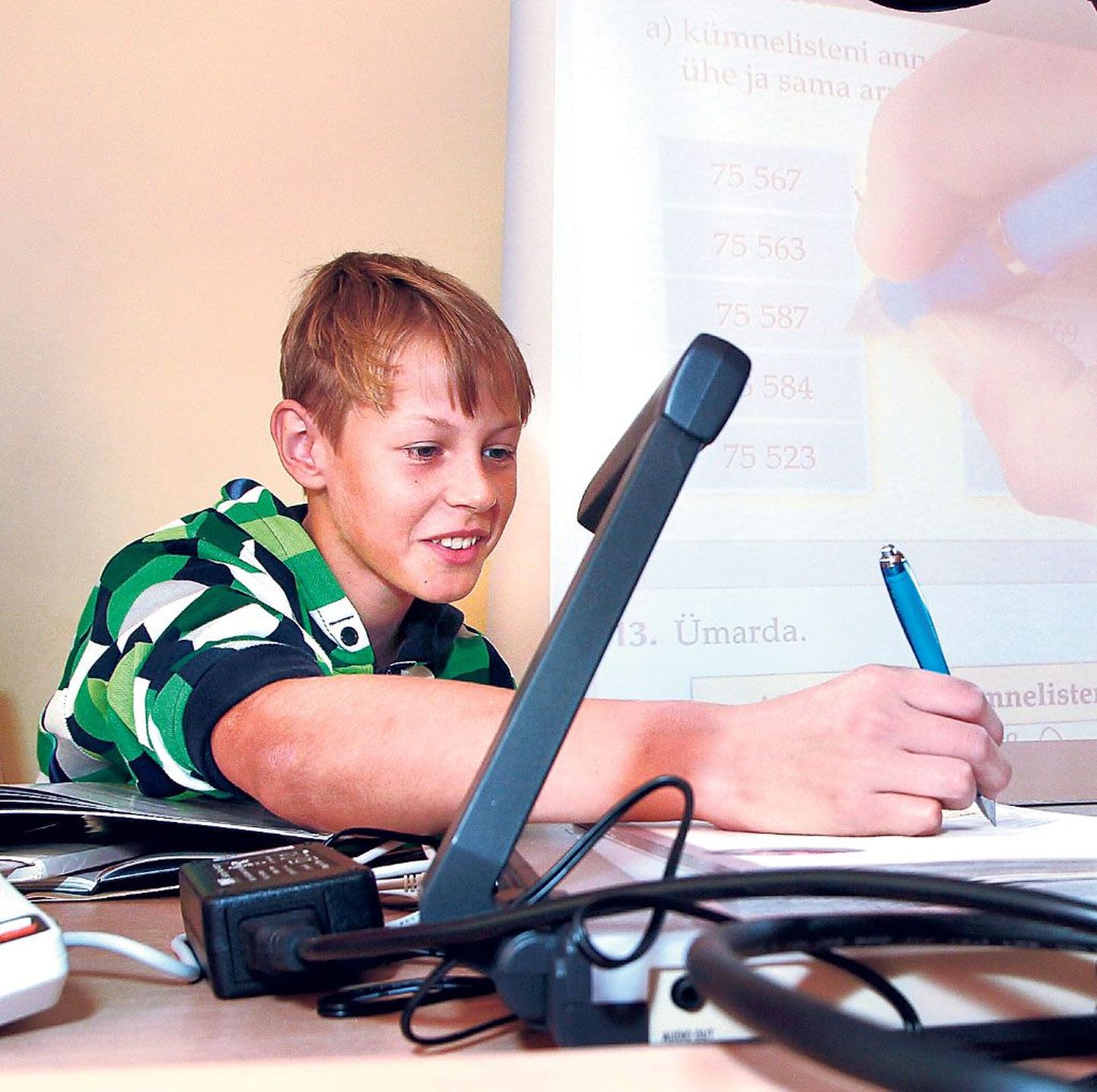 Pärnu Raeküla kooli 5.b klassi poiss Kevin Lehiste lahendab dokumendilugeja all ülesannet.