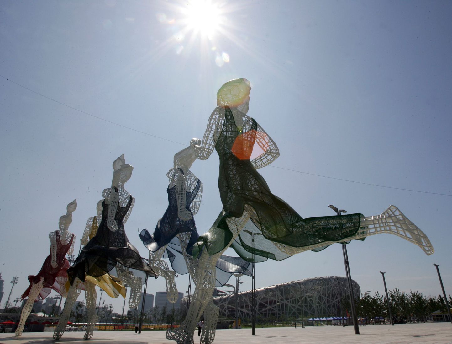 Pekingis paistis päike. Tagaplaanil olümpiastaadion, ees olümpiateemaline skulptuur.