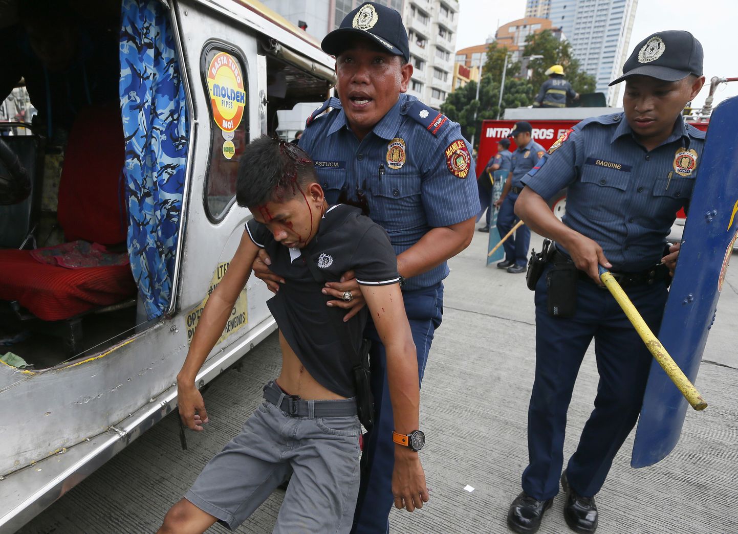 Manila politsei lohistamas vigastatud meeleavaldajat sündmuskohalt.