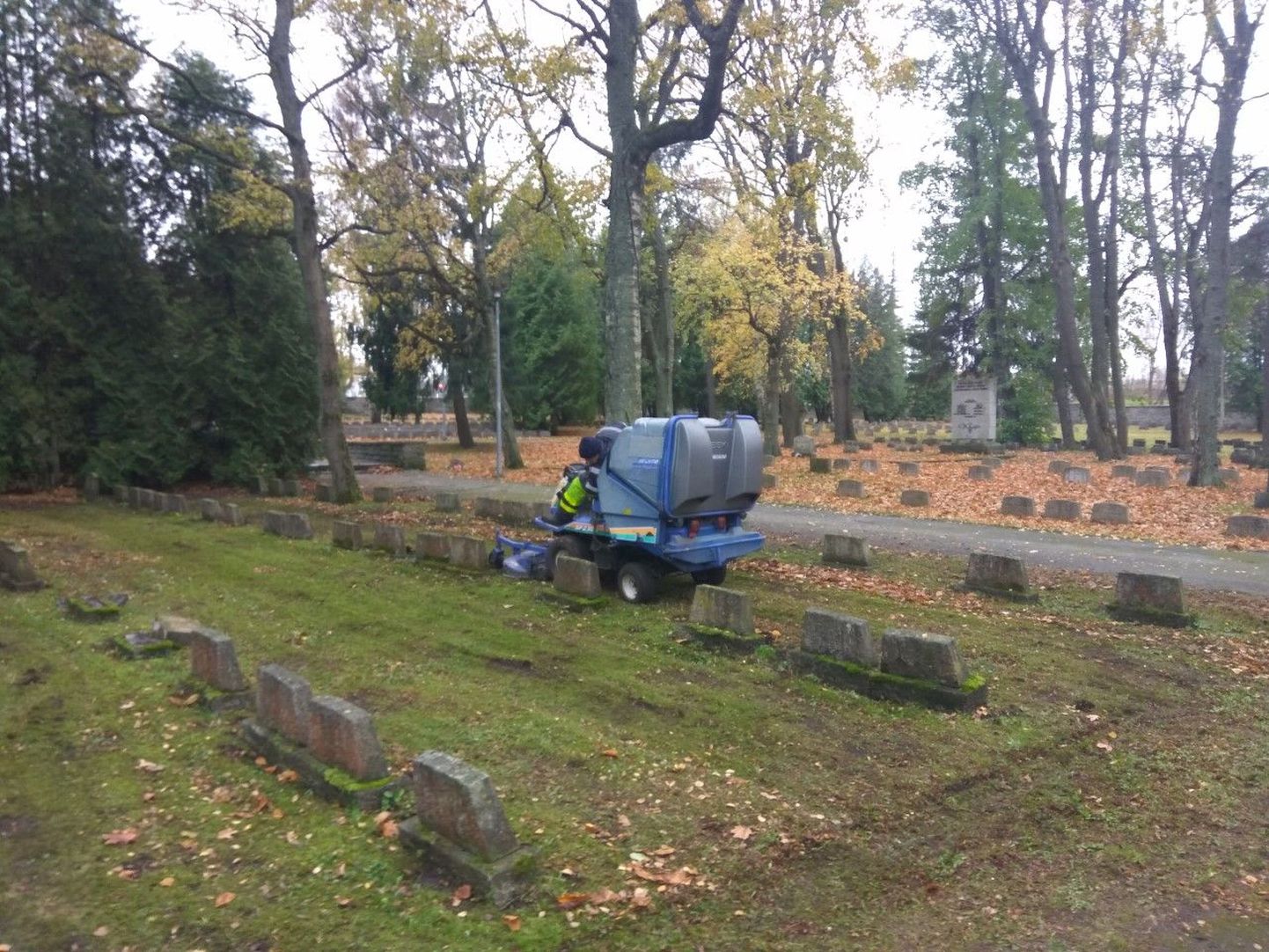Военное кладбище в Таллинне убирают и при помощи техники.