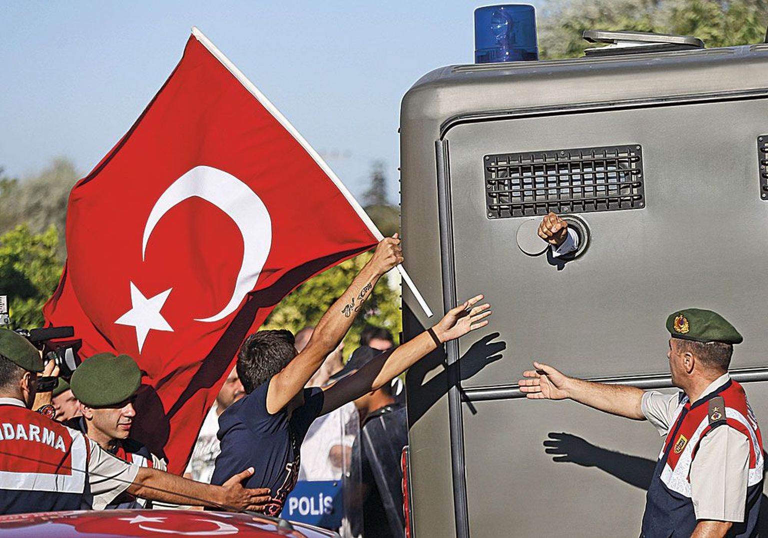 Türgi lipuga meeleavaldajad jooksis järele vanglaautole, millest paistis ühe Silivri kohtumajast minema toimetatud süüaluse rusikas.