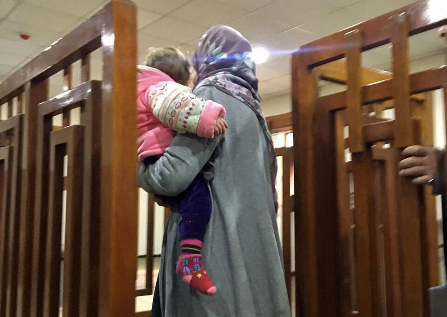 Melina Boughedir lapsega viiakse Baghdadis kohtumajja.