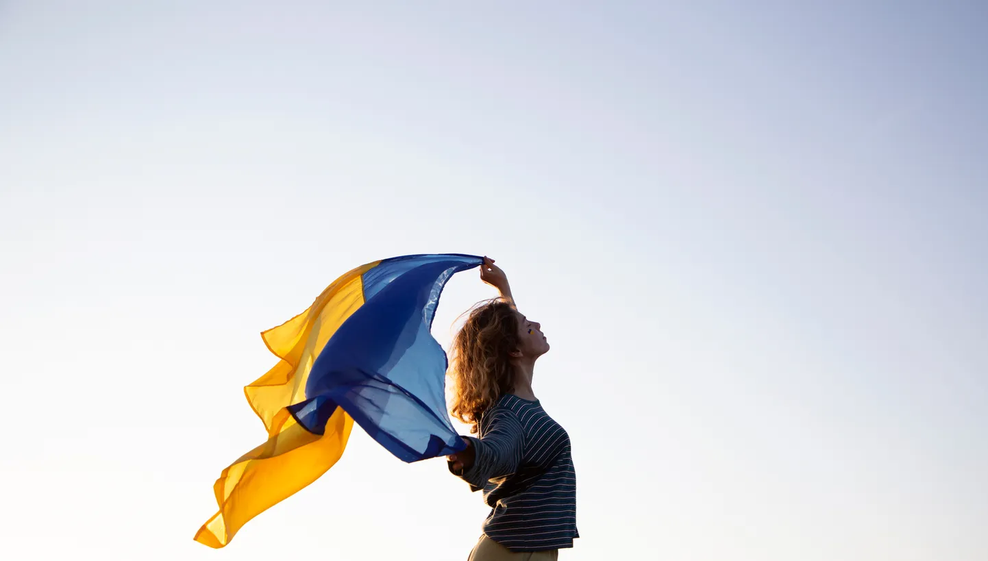 Naine Ukraina lipuga. Pilt on illustreeriv