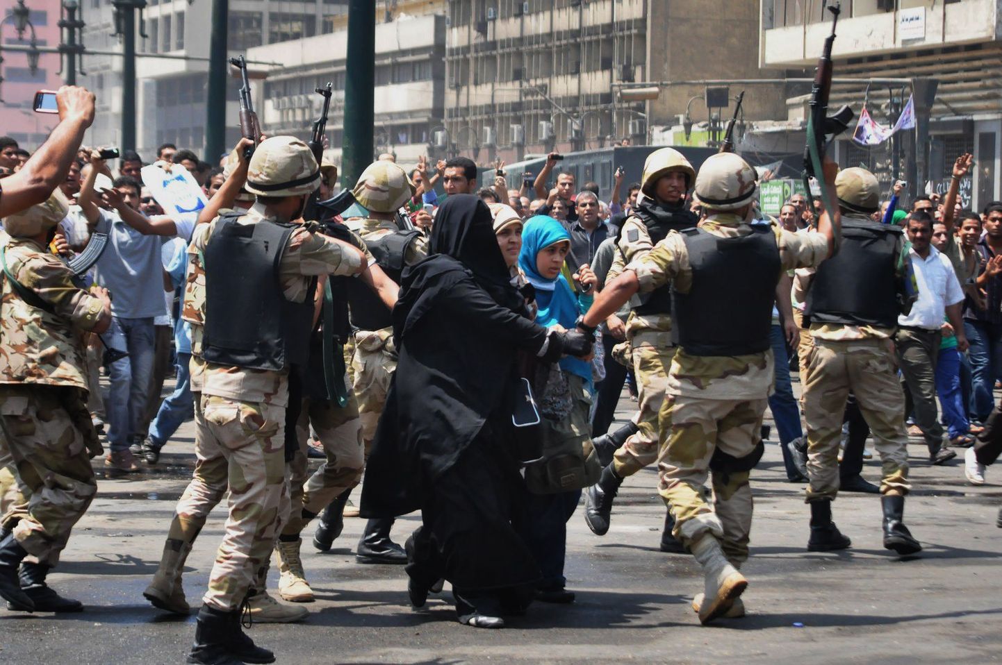 Egiptuse julgeolekujõud eskordivad Moslemivennaskonna toetajaid läbi vihase rahvahulga al-Fatah' mošeest välja.