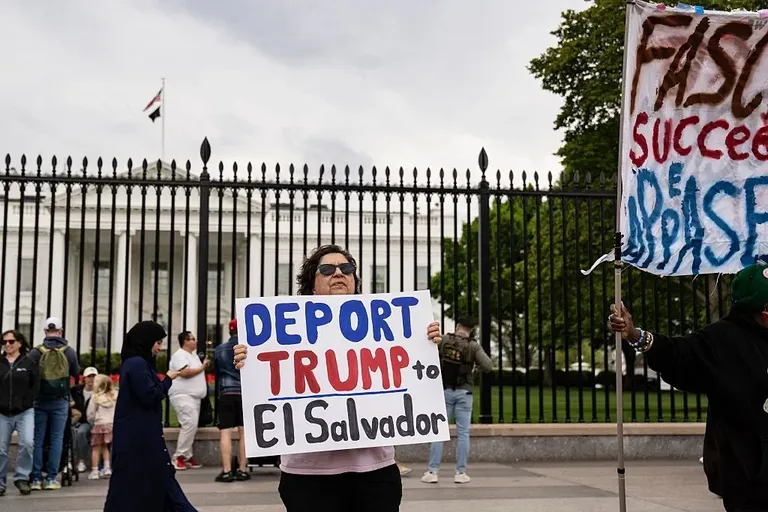 Протестующая около Белого дома с плакатом «Депортируйте Трампа в Сальвадор».