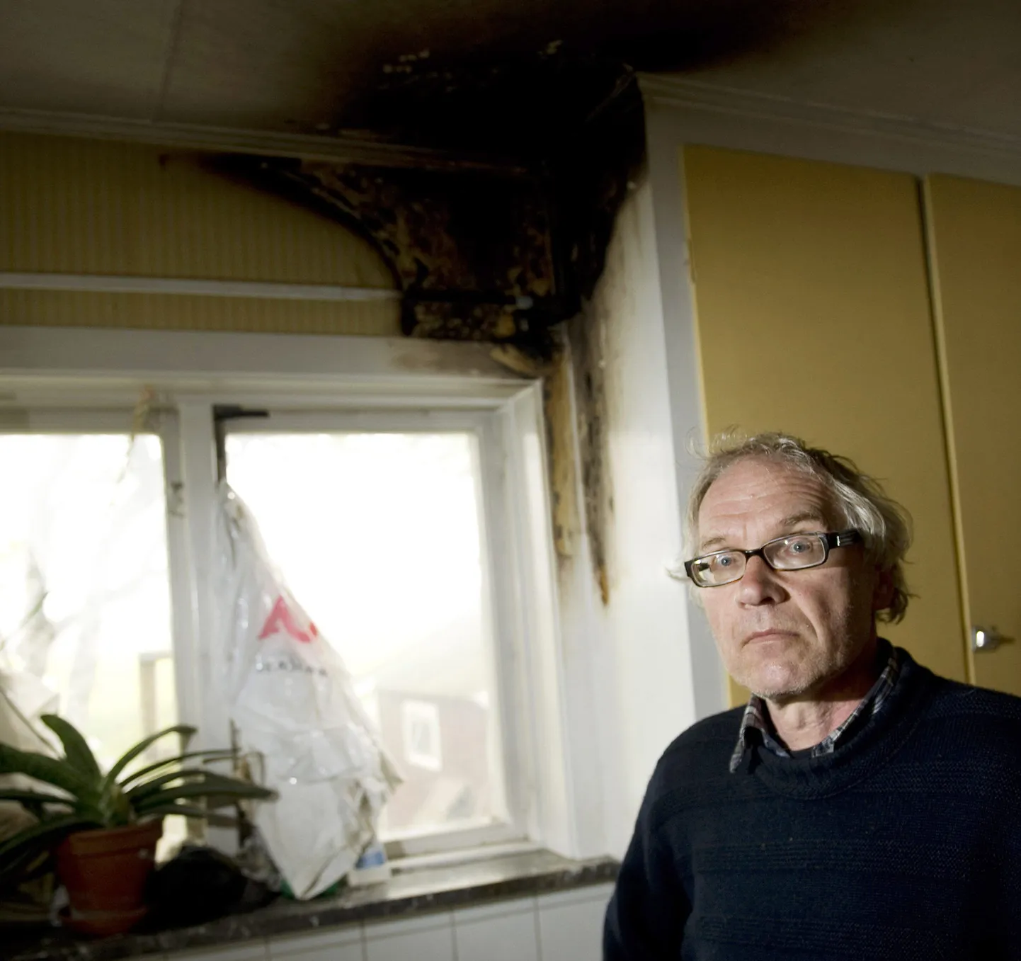 Lars Vilks täna oma põletada saanud köögiakna ees.