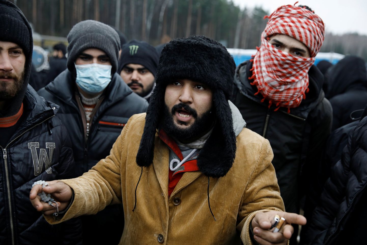 Migrants kopā ar citiem migrantiem ārpus transporta un loģistikas centra pie Baltkrievijas un Polijas robežas, Grodņas apgabalā.