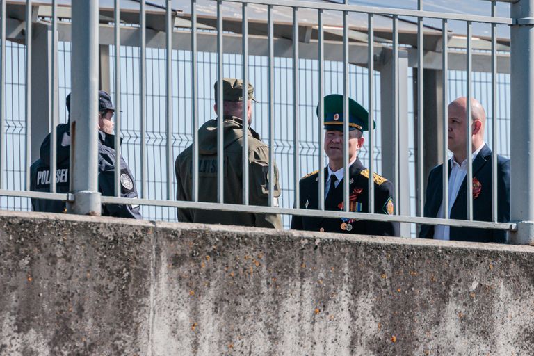 Эстонские и российские пограничники спорят на Нарвском мосту из-за плаката, называющего президента соседней страны военным преступником.