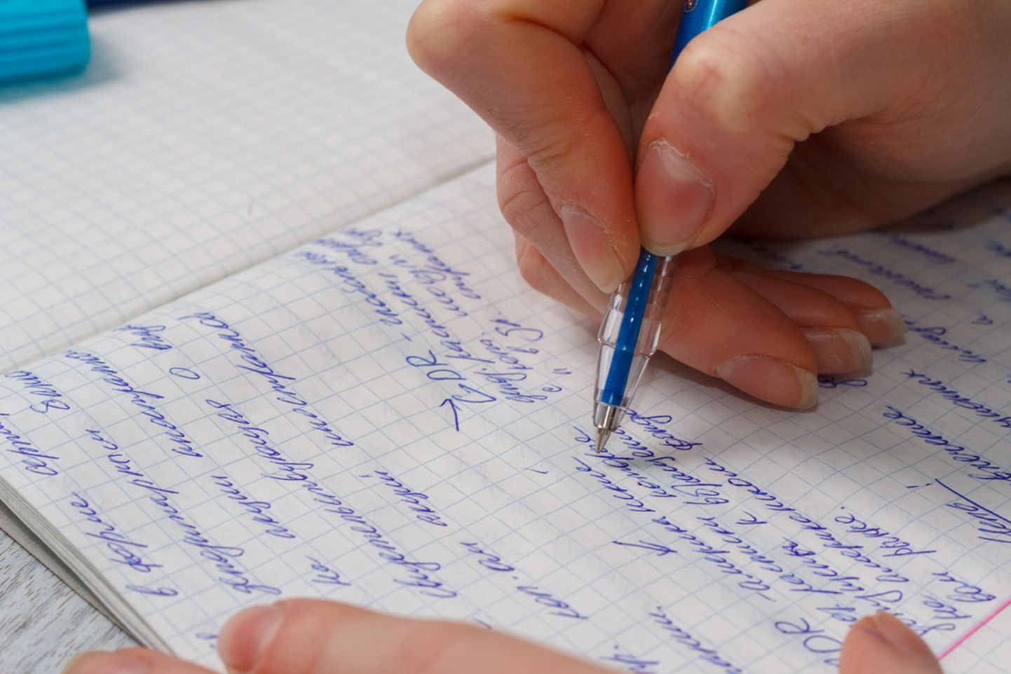 Ruuduline vihik ja sinine pastakas, käsitsi kirjutamise klassika