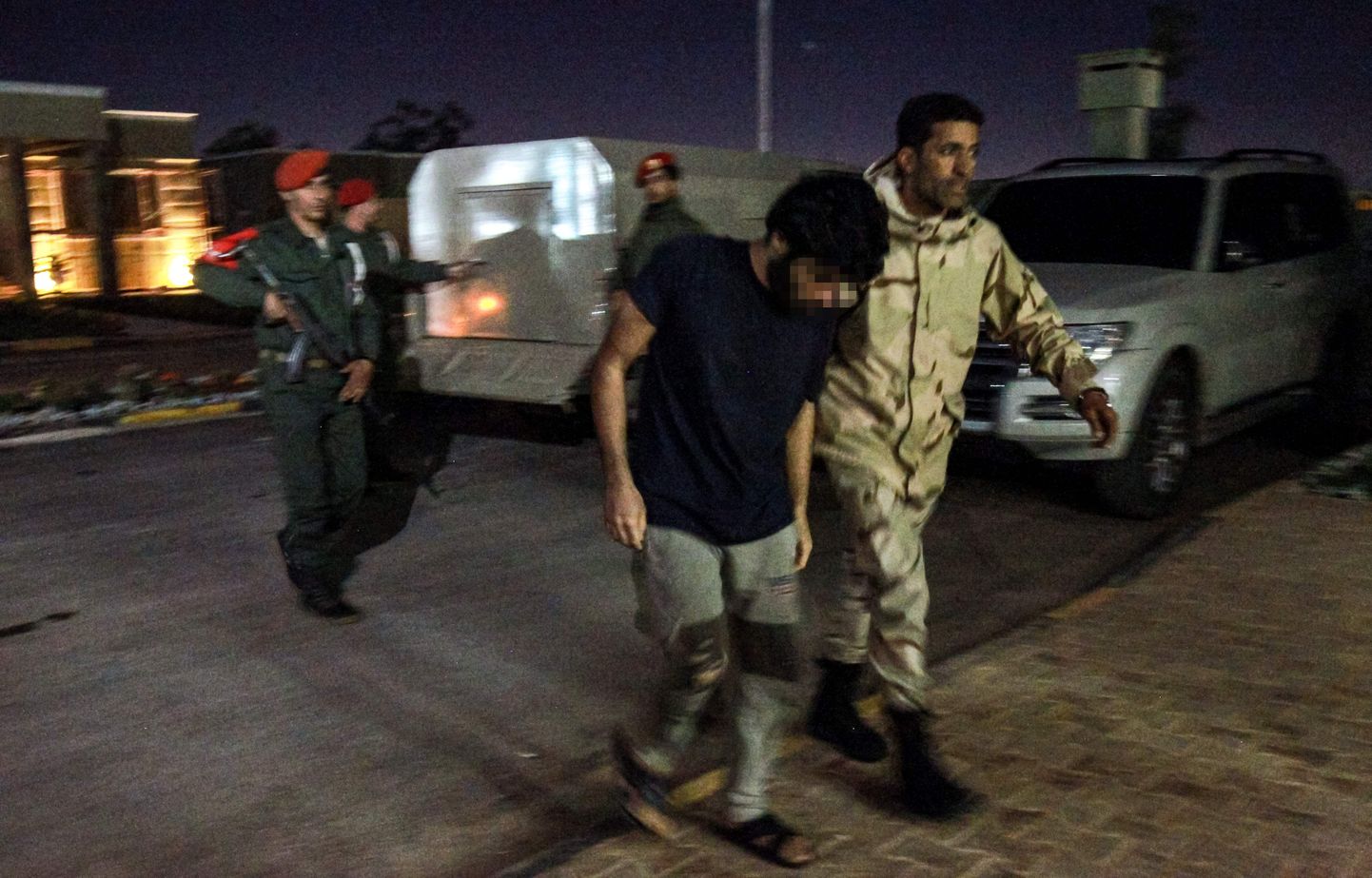Liibüa idaosas paiknevas Benghazi linnas, mis hetkel on mässulise väepealiku Khalifa Haftari kontrolli all, 5. mail tehtud fotol eskordib Haftari-meelne sõdur keskvalitsuse eest võidelnud meest, kes võeti vangi varem pealetungi käigus pealinna Tripoli lähistel. Haftarile ustavad võitlejad kahtlustavad meest Süüriast saabunud palgasõdurite sekka kuulumises, kelle tõid Liibüasse nende sõnul väidetavalt Türgi võimud.