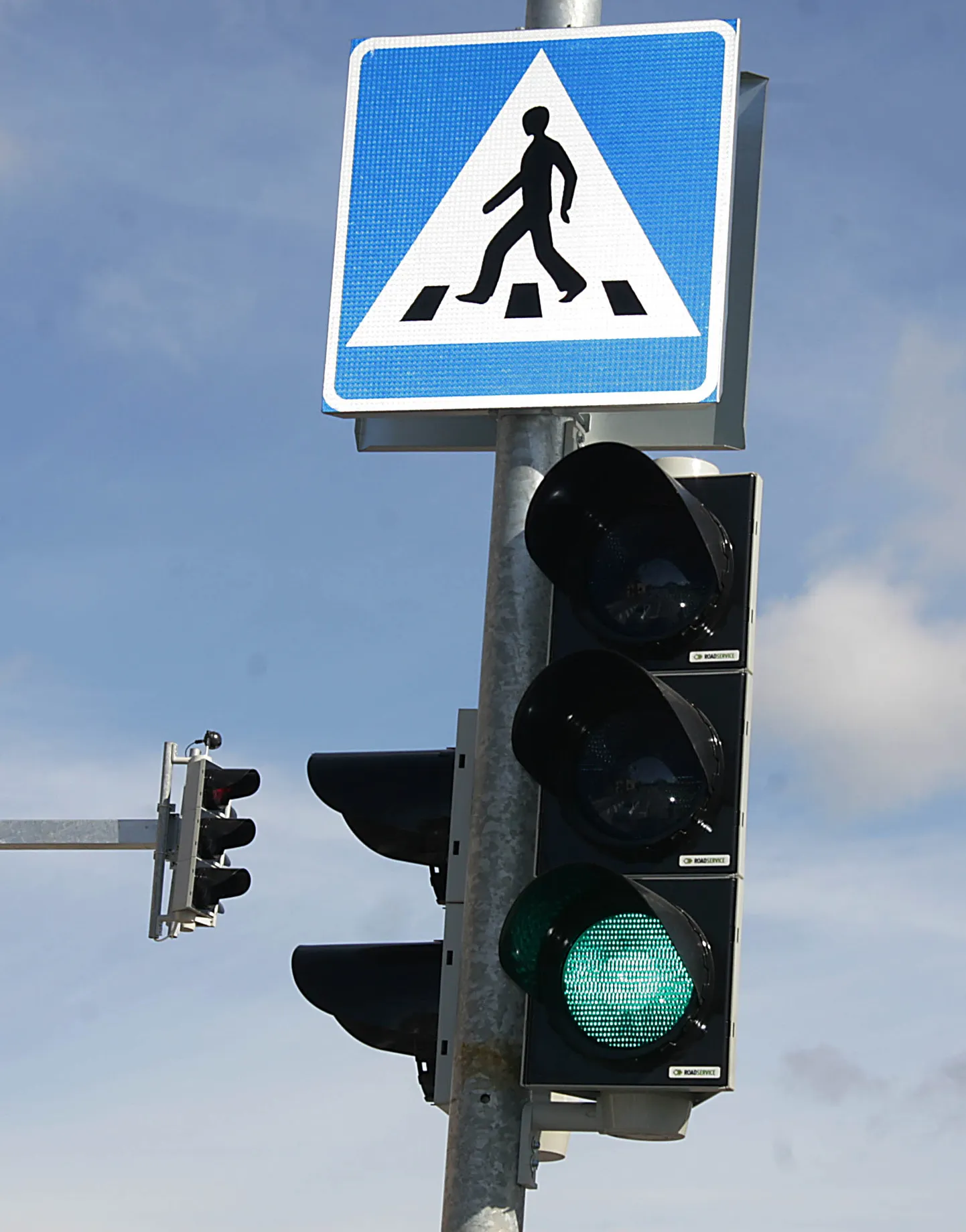Светофор и дорожный знак пешеходного перехода.