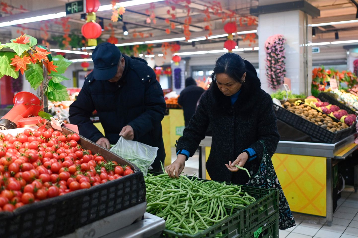 Inimesed Pekingis asuvas supermarketis köögivilju valimas.