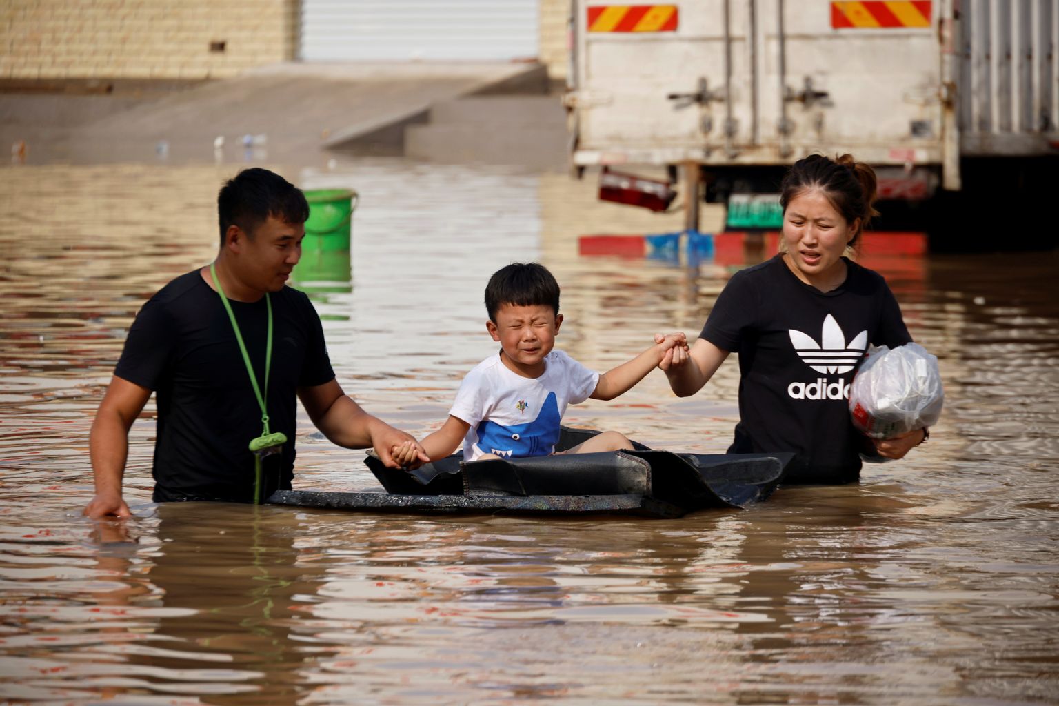 Vanemad evakueerimas oma last Hiina Henani provintsi Zhengzhou üleujutusalal