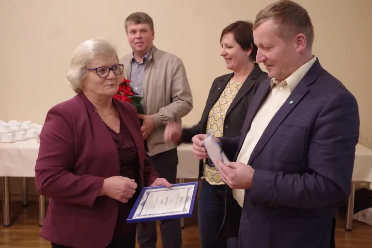 Karilatsi külavanemat õnnitlesid Põlvamaa Partnerluskogu juhatuse esimees, Kanepi vallavanem Andrus Seeme (esiplaanil), partnerluskogu tegevjuht Tiiu Rüütle ja Põlva vallavolikogu esimees Lennart Liba (taamal).
