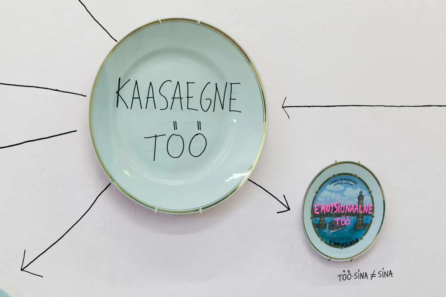 Detail teosest «Võltspuhkaja suveniirid». 47 suveniirtaldrikut, tekst klaasil ja seinal, erinevad suurused, jätkuv, 2019.