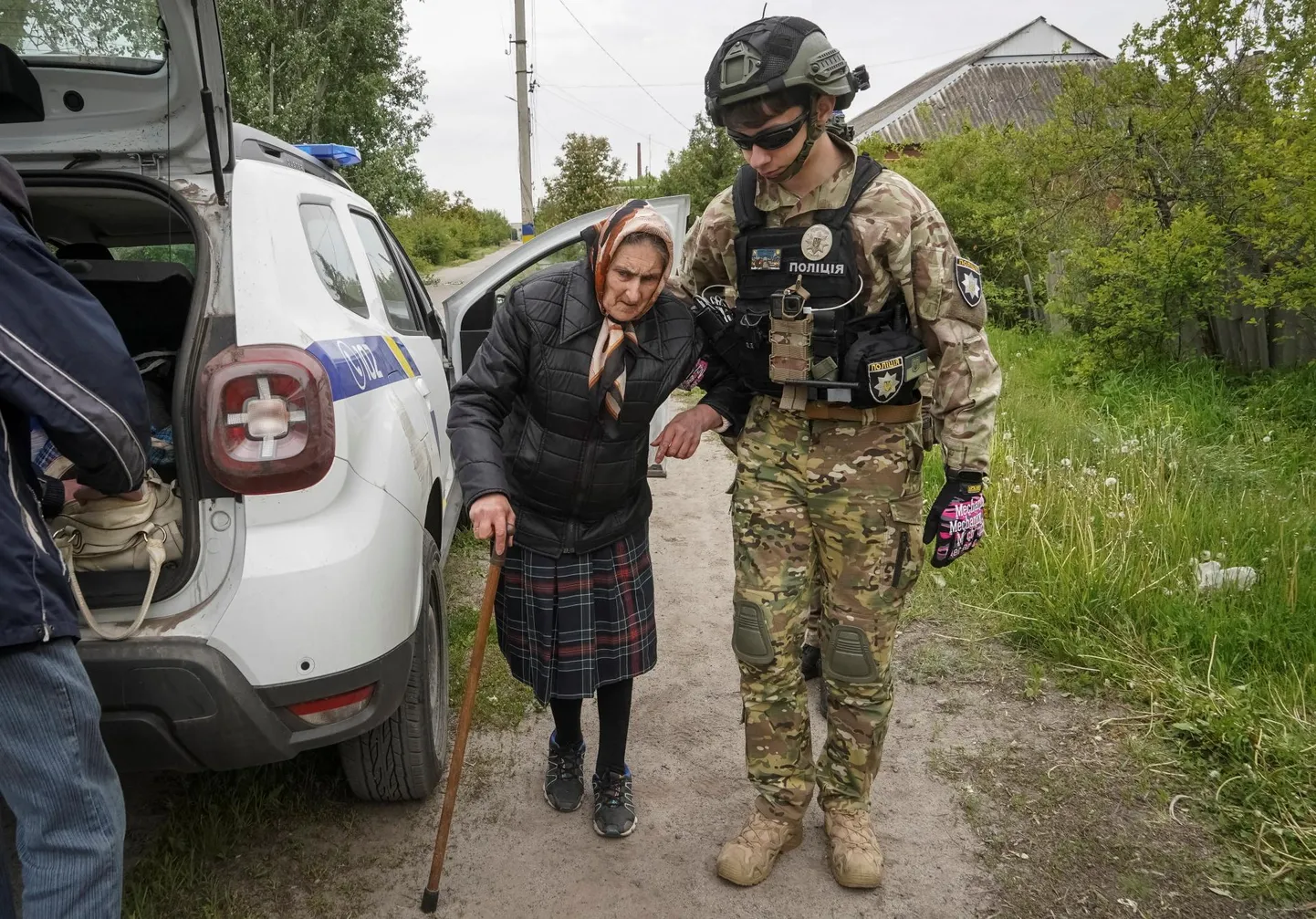 Politseiohvitser aitab Vovtšanski elanikku Harkivisse evakueerimise ajal.