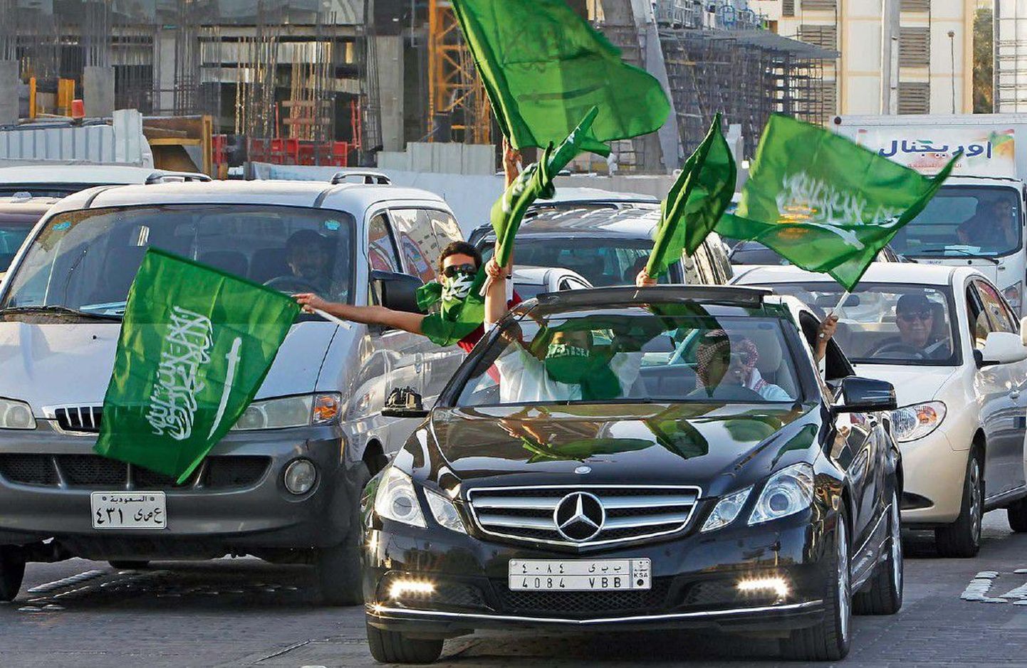 Saudi rahvuslipud tänavail pärast kuninga erakorralist telepöördumist, milles riigipea teatas palkade ja toetuste suurendamisest.