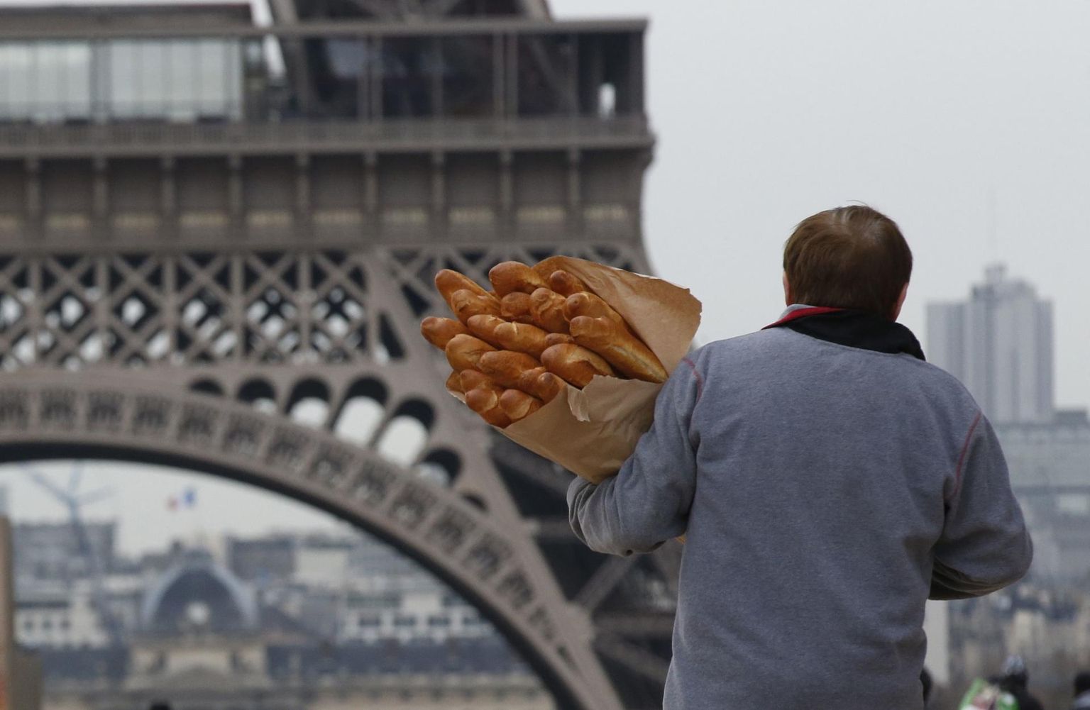 Mees baguette’idega Pariisis Eiffeli torni juures.