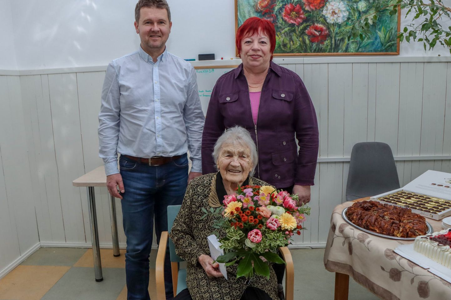 Juubilar Linda Sarapuu koos Võru vallavanema Kalmer Puusepa ja sotsialtöötaja Aino Kaursoniga.