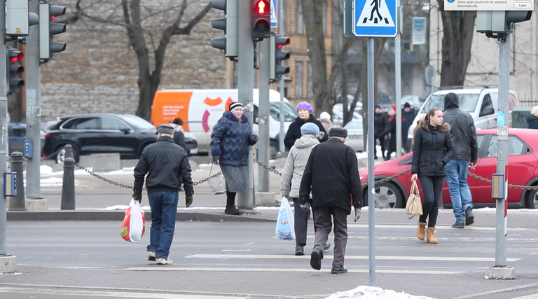 Люди в Таллинне переходят дорогу на красный сигнал светофора. 