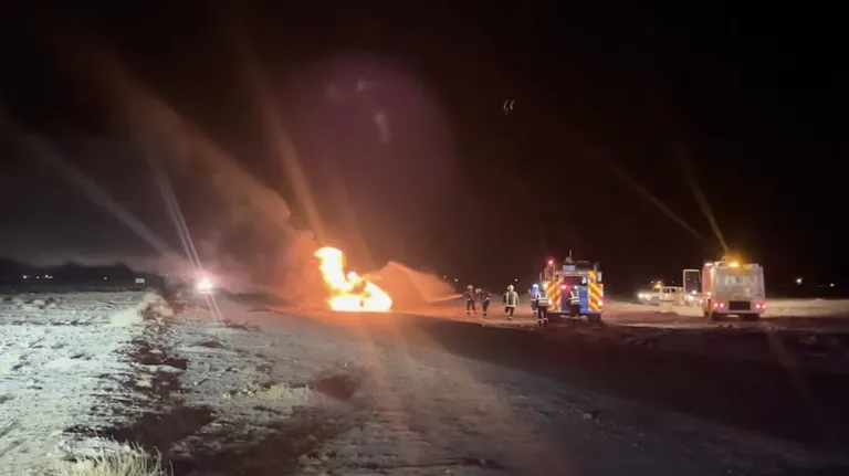Tuletõrjujad kustutamas põlema süttinud eestlaste ralliautot.