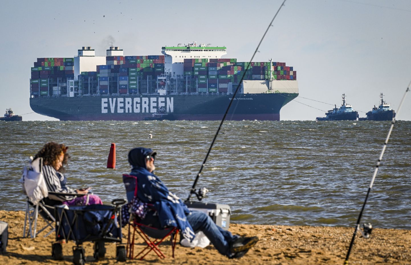 Kalastajad Chesapeake lahe silla lähedal Sandy Point rannas, taamal mudast lahti tõmmatud konteinerilaev Ever Forward sadama poole suundumas. (Jerry Jackson/The Baltimore Sun via AP)