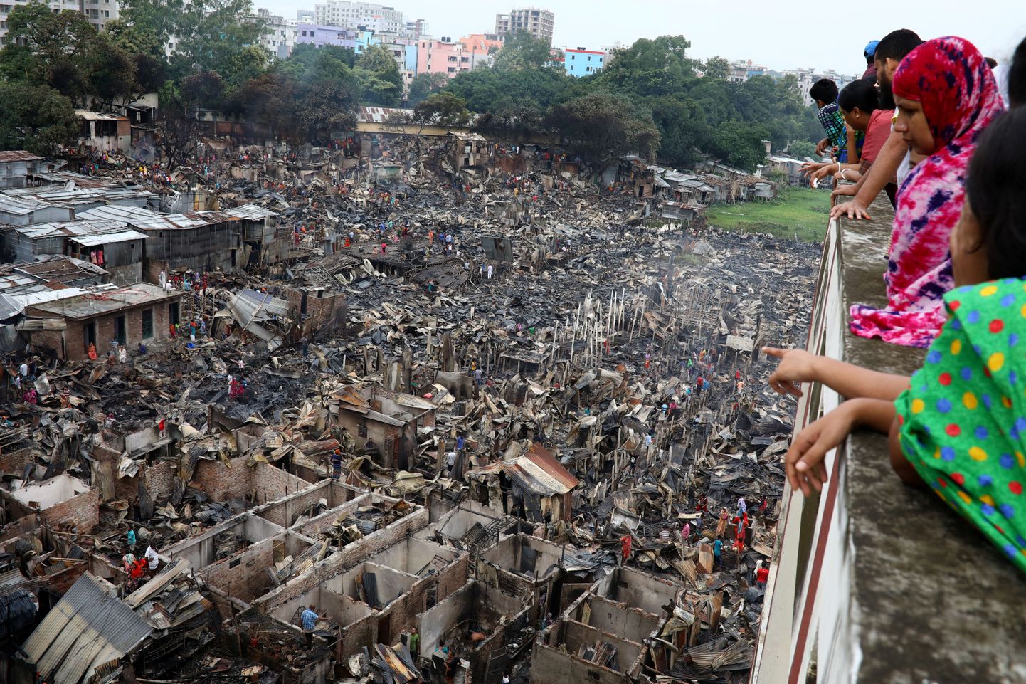 Inimesed vaatamas Dhaka slummis maha põlenud hooneid.
