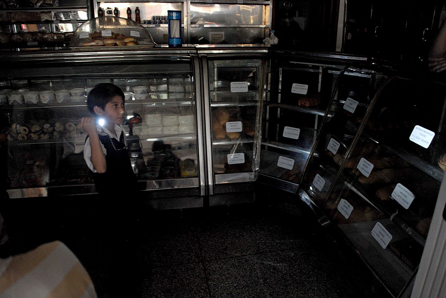 Venetsueela jaoks on pidevad voolukatkestused argipäev. Pildil taskulambiga poiss ühes pagaritöökojas.