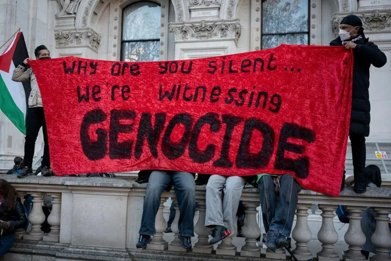 «Почему вы молчите... Мы становимся свидетелями геноцида» - написано на этом плакате