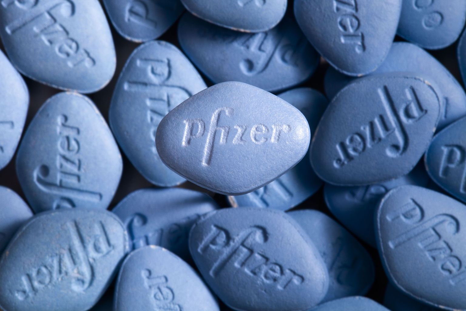 Esiplaanil on tõeline Viagra tablett, võltsitud tablettide taustal.