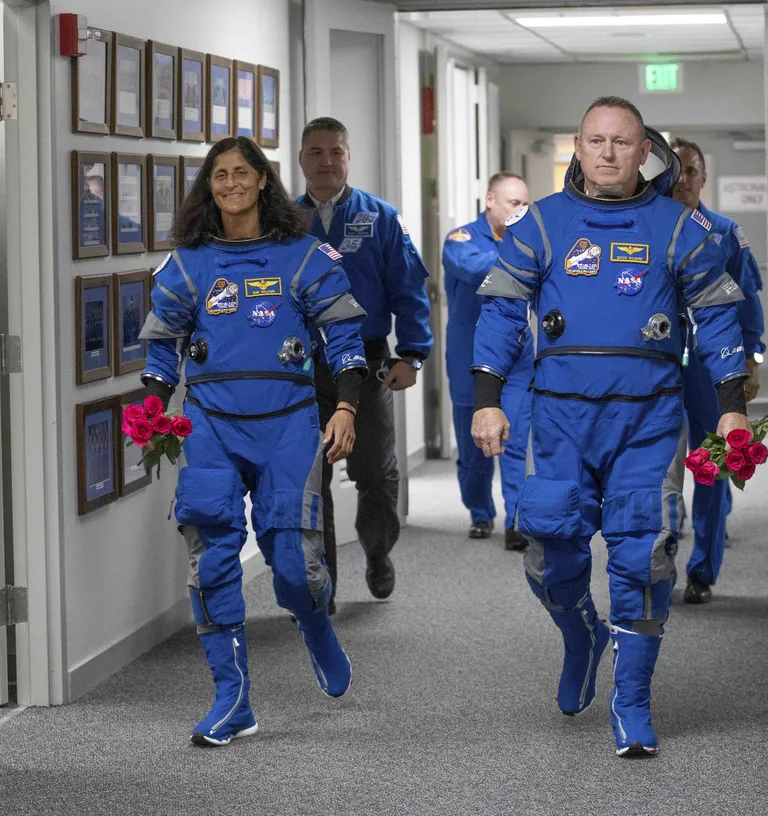 NASA astronaut Butch Wilmore (paremal) ja meeskonnakaaslane Suni Williams (vasakul), roosid käes, jalutavad 6. mail 2024. aastal Floridas Cape Canaverali kosmosekeskuses.