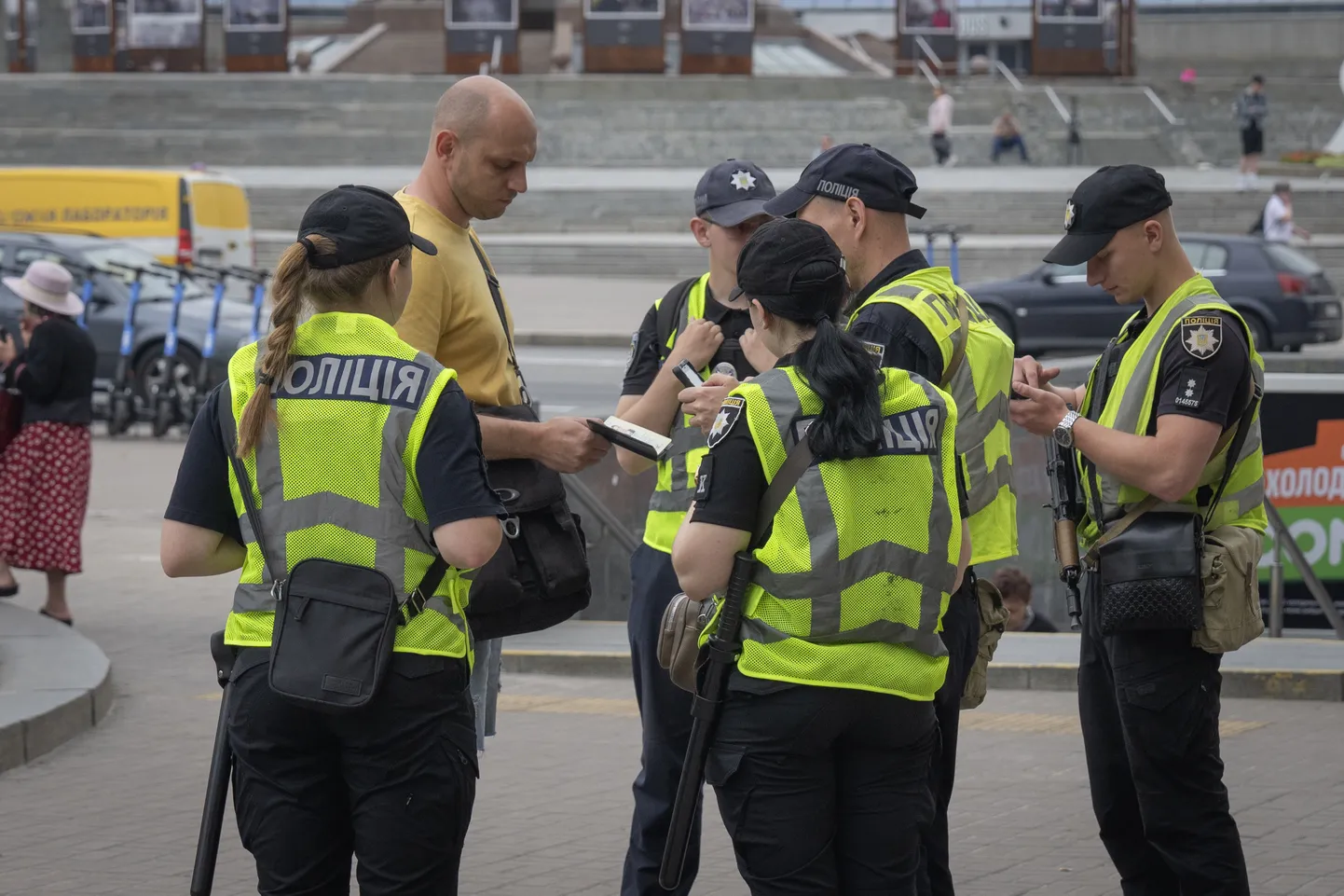 Сотрудники полиции проверяют документы у мужчины для поиска лиц, уклоняющихся от мобилизации в Киеве.