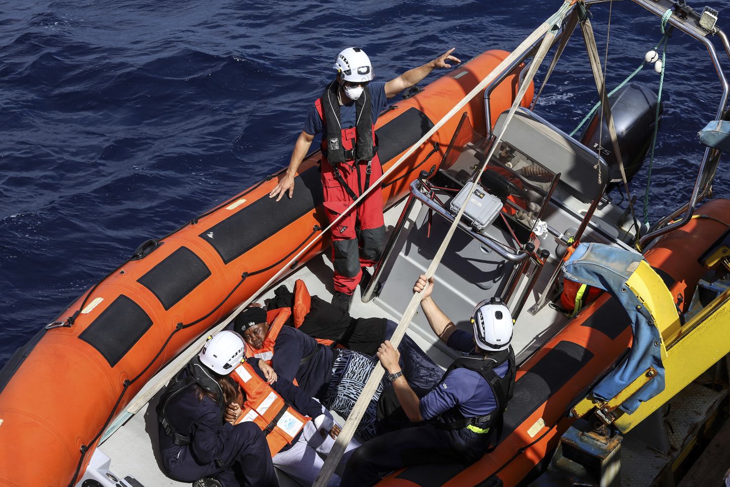 Itaalia rannavalve päästepaat toimetab merehädalisi suurema laeva pardale. Foto ei ole seotud artikli puksiiriõnnetusega. (AP Photo/Valeria Mongelli)