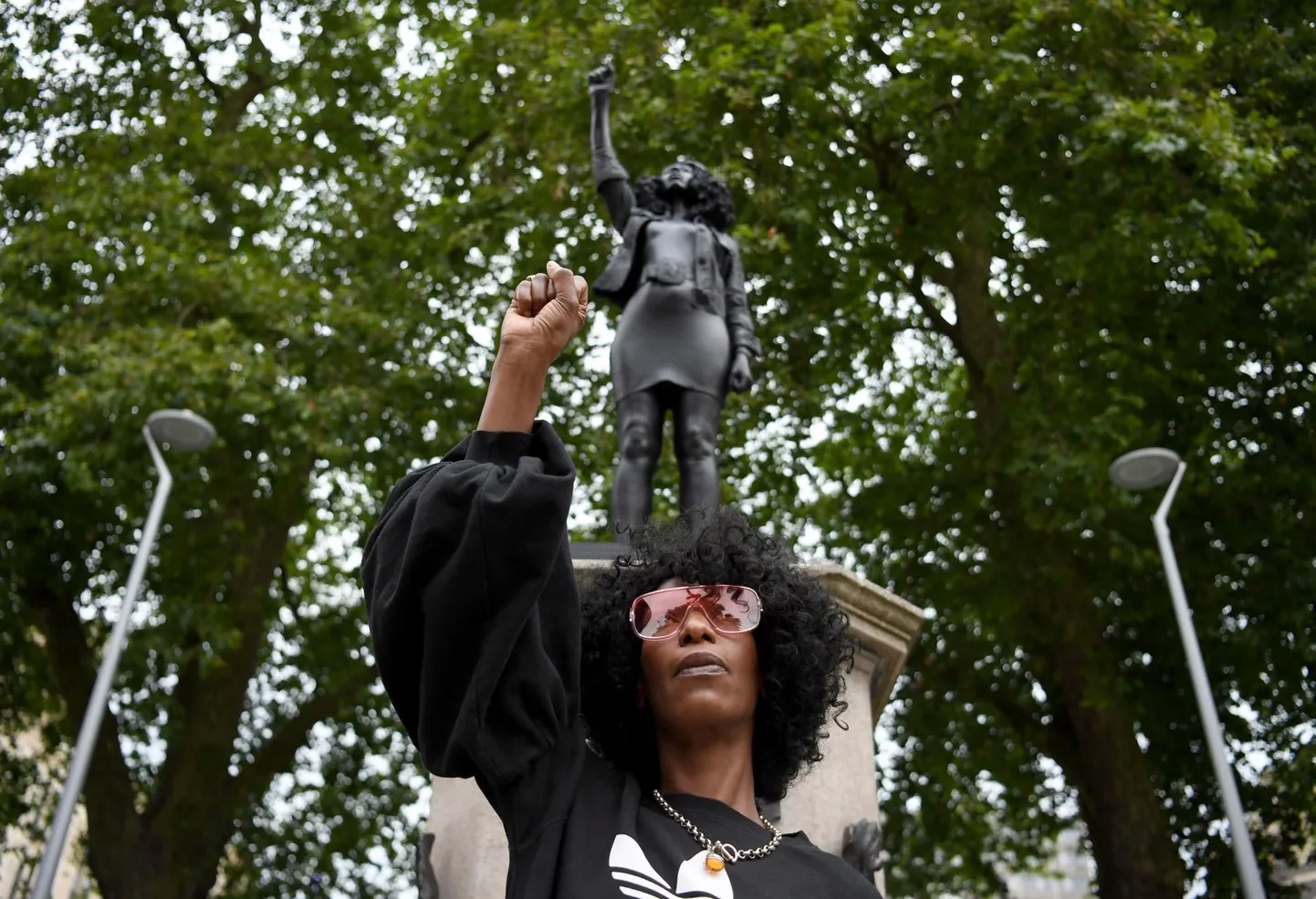 Jen Reid poseerimas eile teda kujutava kuju «Kasvav jõud» ees Bristolis. Skulptuuri autori Marc Quinn sõnul soovib ta teosega hoida elus arutelu rassismi üle.