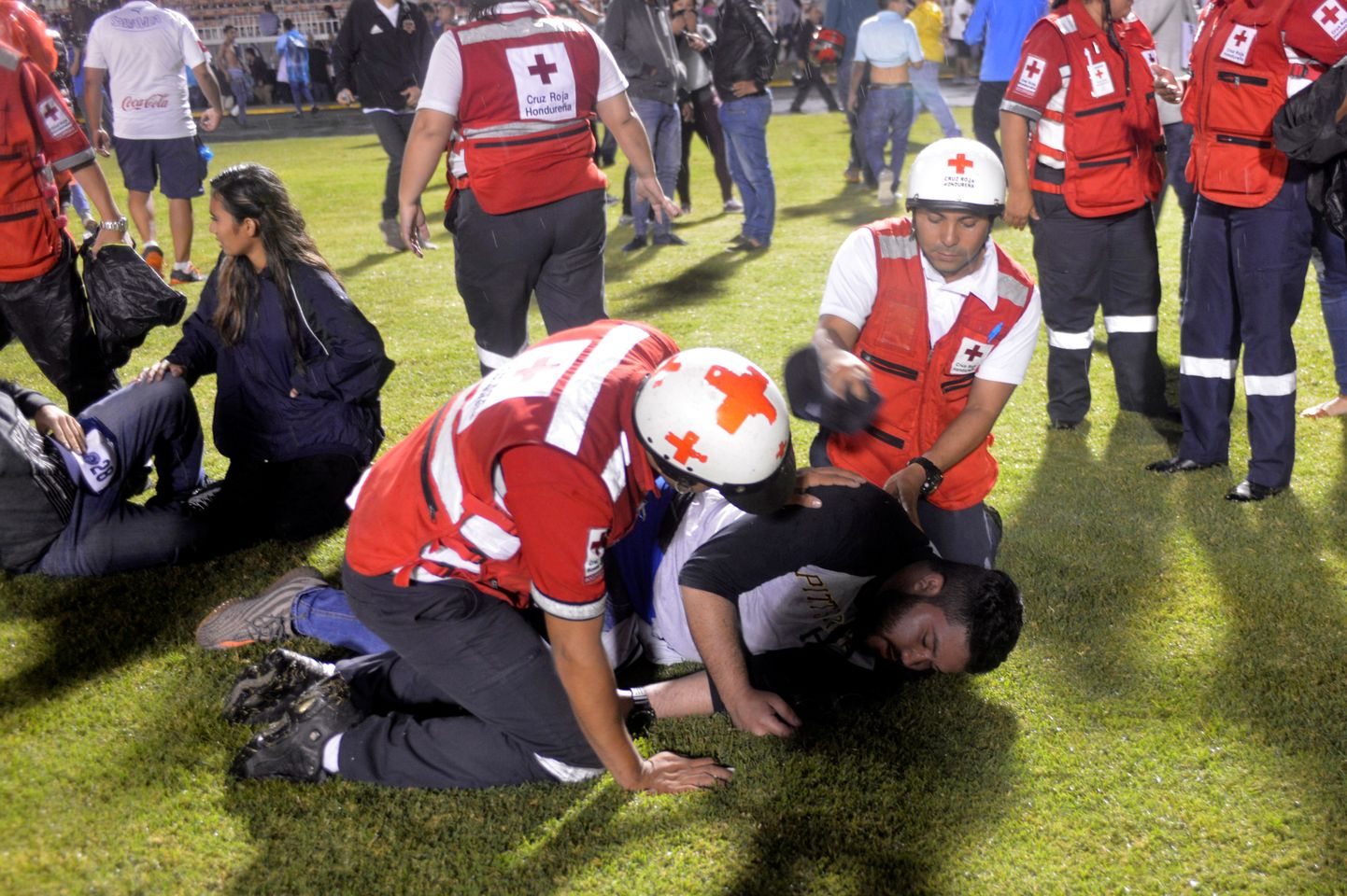 Arstid turgutamas fänni, kes hingas Tegucigalpas jalgpallimängu eel puhkenud rahutustes sisse pisargaasi.