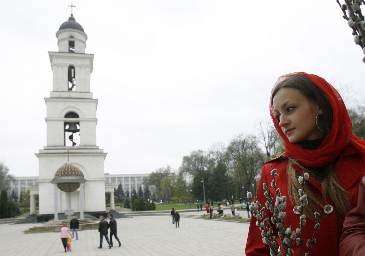 Жительница Молдовы перед православной церковью.