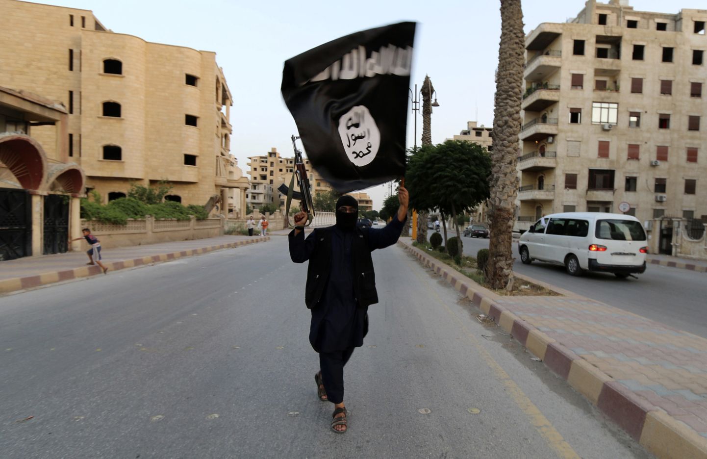 A member loyal to the Islamic State in Iraq and the Levant (ISIL) waves an ISIL flag in Raqqa June 29, 2014. The offshoot of al Qaeda which has captured swathes of territory in Iraq and Syria has declared itself an Islamic "Caliphate" and called on factions worldwide to pledge their allegiance, a statement posted on jihadist websites said on Sunday. The group, previously known as the Islamic State in Iraq and the Levant (ISIL), also known as ISIS, has renamed itself "Islamic State" and proclaimed its leader Abu Bakr al-Baghadi as "Caliph" - the head of the state, the statement said. REUTERS/Stringer (SYRIA - Tags: POLITICS CIVIL UNREST TPX IMAGES OF THE DAY)